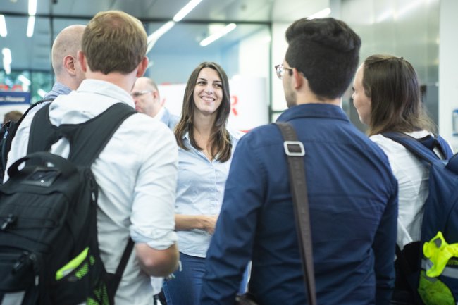 1 Ausstellerin der Firmen-Messe der Bahnindustrie beratet am Stand Studierende