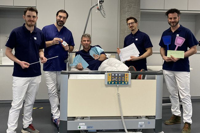 Das Team der Lehrveranstaltung am Gruppenbild, einige von den Lehrenden sitzen dafür im Pflegebett