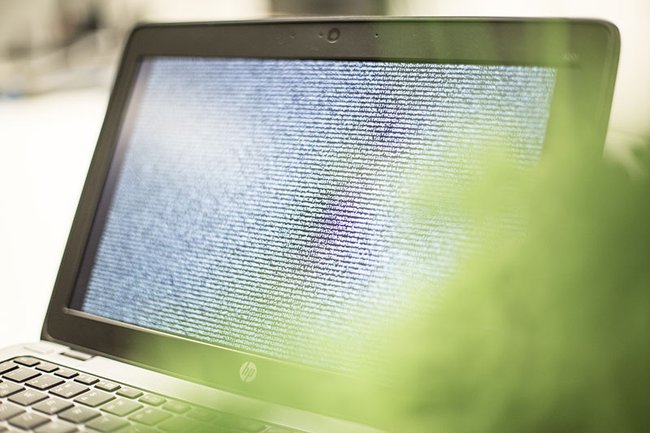 Symboldbild: Laptop mit Code auf dem Bildschirm