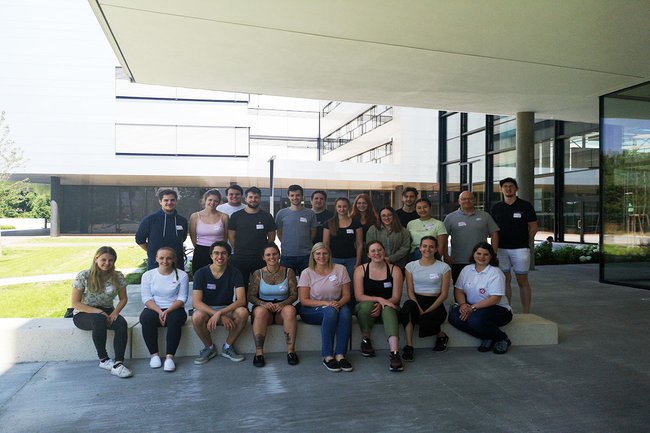 Gruppenfoto der Lehrgangsabsolvent*innen der präklinischen Notfallmedizin vordem Haupteingang des neuen Gebäudes am Campus der FH St. Pölten