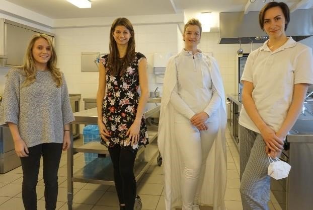 Auf dem Bild sieht man Sophie Breimann, Anja Grünauer, Teresa Fleischhacker und Petra Fürnkranz in der Betriebsküche stehen.